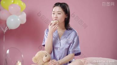坐在床上吃甜甜圈的年轻女孩